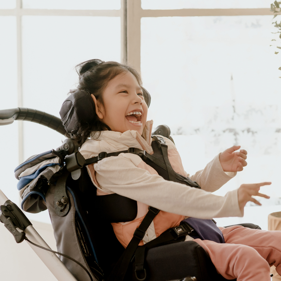 Little girl laughing in a chair