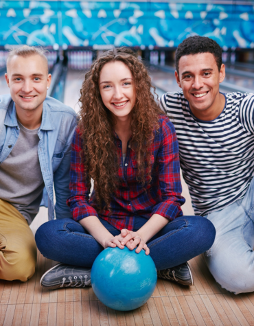teens sitting with bowling balls