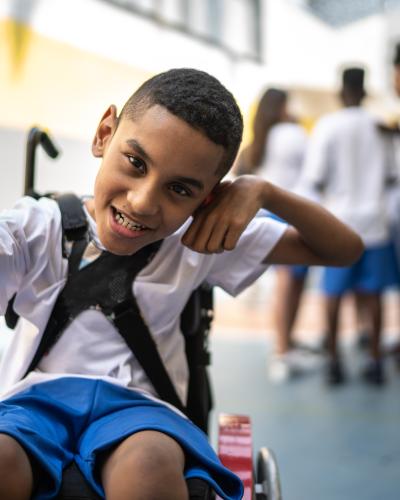 Child in wheelchair posing with a punching motion.