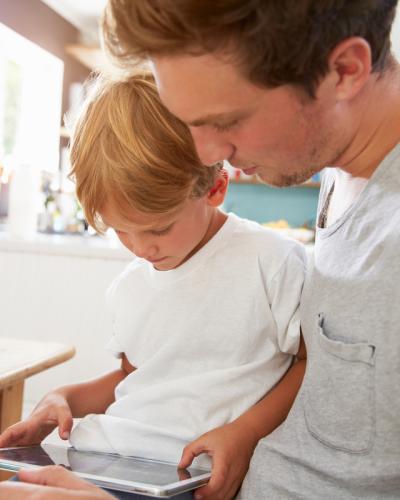 Man and child looking at tablet.